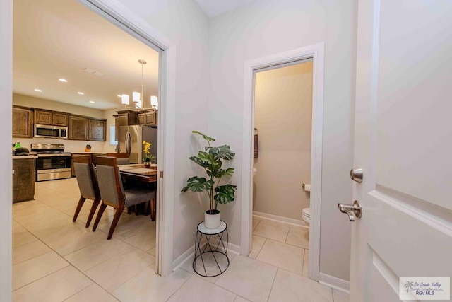 interior space with recessed lighting, baseboards, a notable chandelier, and light tile patterned flooring