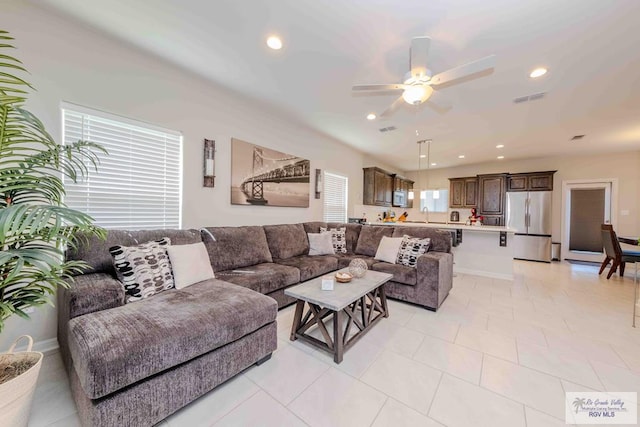 living area with light tile patterned floors, baseboards, visible vents, a ceiling fan, and recessed lighting