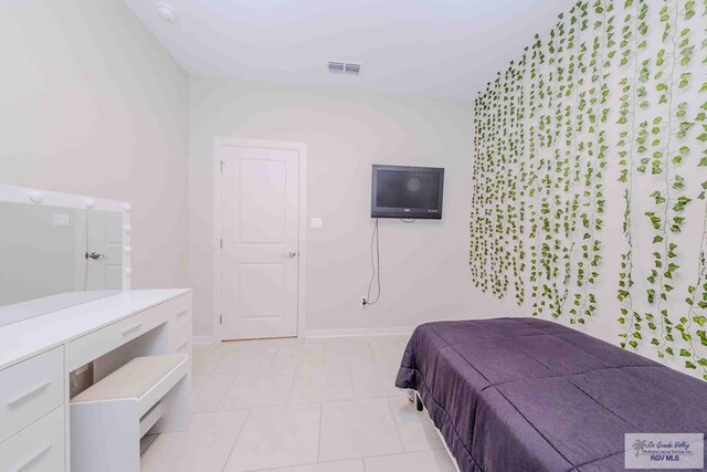 bedroom with light tile patterned floors, baseboards, and visible vents