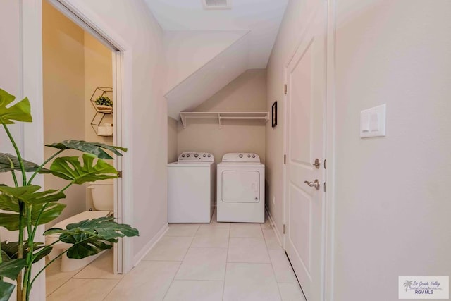 laundry area with light tile patterned flooring, laundry area, separate washer and dryer, visible vents, and baseboards