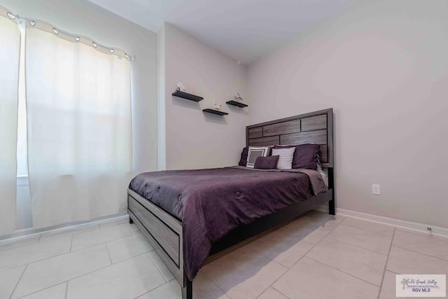 bedroom with baseboards and light tile patterned floors