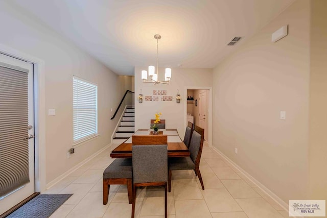 dining area with stairs, visible vents, a notable chandelier, and light tile patterned flooring