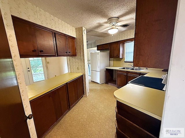38 Palmetto Cir, Brownsville, TX 78521 - kitchen with freestanding refrigerator, wallpapered walls, a sink, light countertops, and ceiling fan