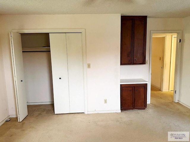 38 Palmetto Cir, Brownsville, TX 78521 - unfurnished bedroom featuring light colored carpet, a closet, baseboards, and a textured ceiling