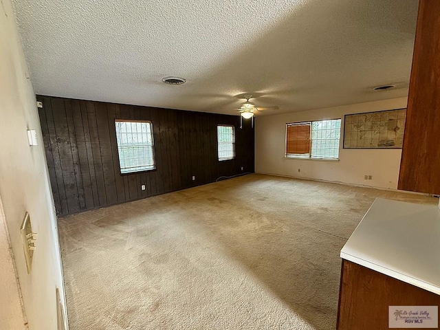 38 Palmetto Cir, Brownsville, TX 78521 - unfurnished room featuring ceiling fan, light carpet, a textured ceiling, and wooden walls