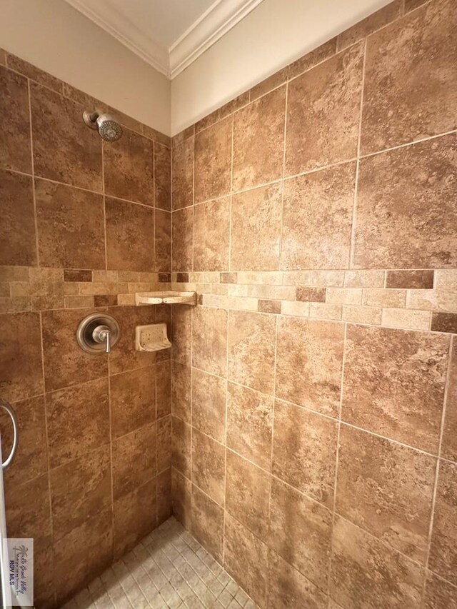 bathroom featuring a tile shower and ornamental molding