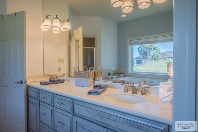 bathroom featuring double vanity, a stall shower, a garden tub, and a sink