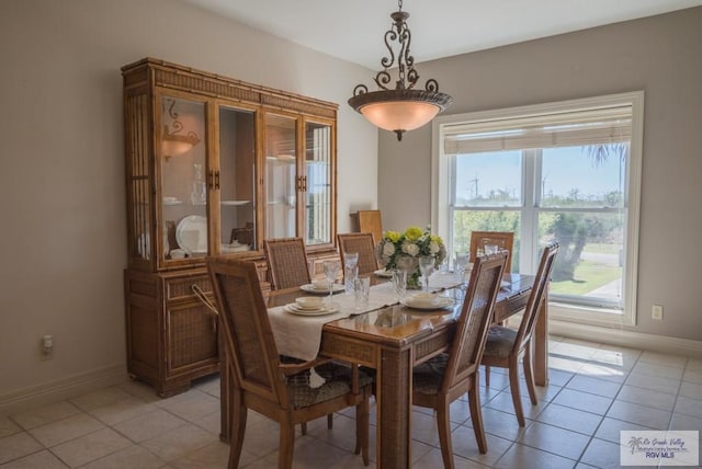 dining space featuring light tile patterned floors and baseboards