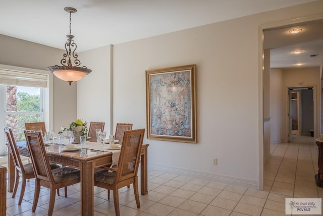 dining area featuring light tile patterned floors and baseboards