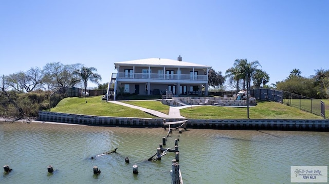 rear view of house featuring a patio area, a water view, a yard, and stairs