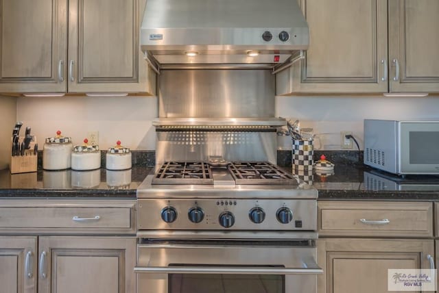 kitchen with dark stone counters and ventilation hood