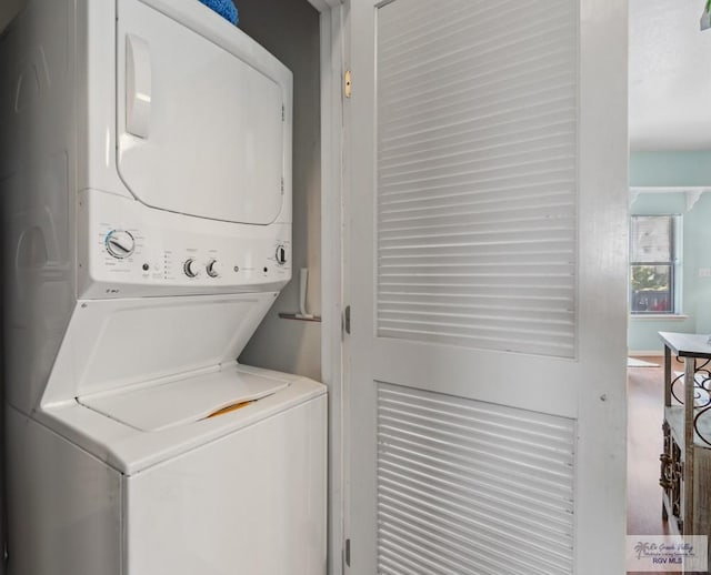 washroom with stacked washer / drying machine and laundry area