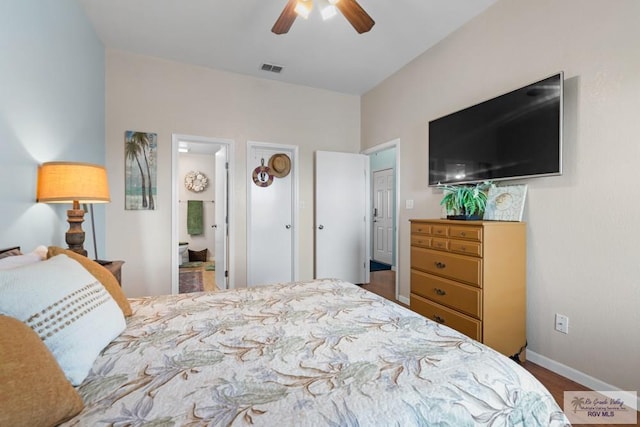 bedroom with a ceiling fan, visible vents, wood finished floors, baseboards, and connected bathroom