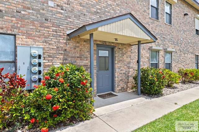 view of exterior entry with brick siding