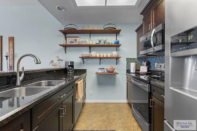 kitchen with open shelves, a sink, dark stone counters, and appliances with stainless steel finishes