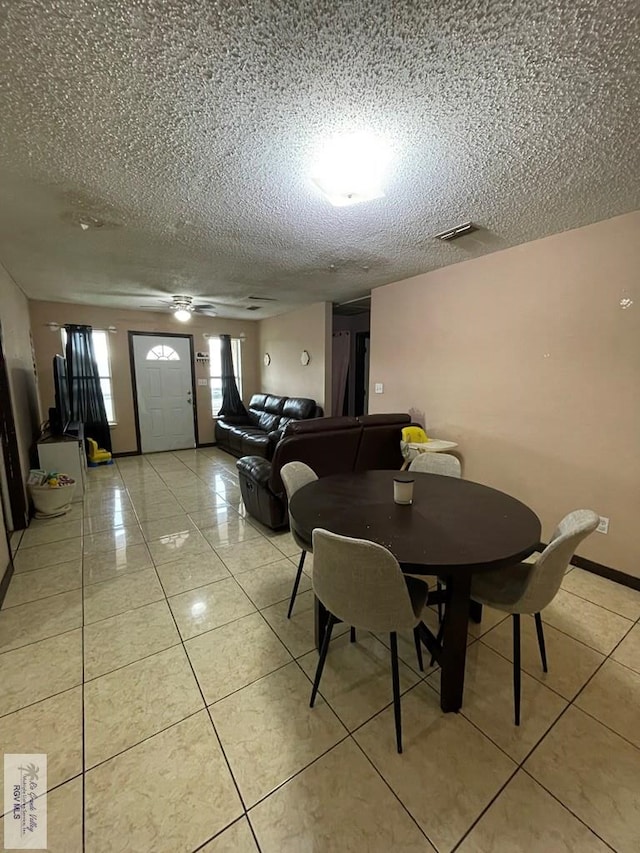 tiled dining space with a textured ceiling