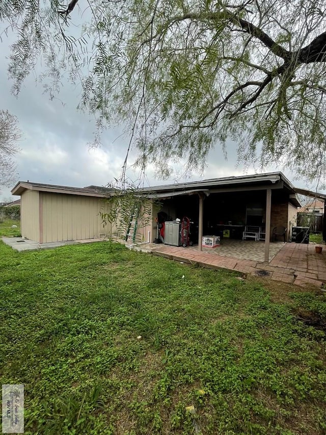 back of house featuring a patio and a yard