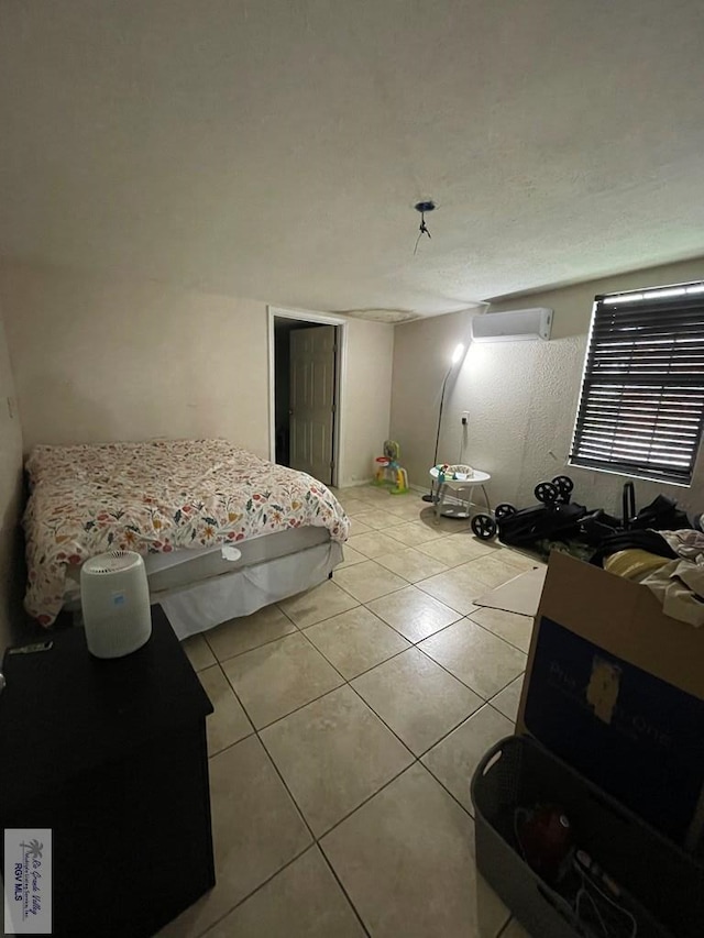 bedroom featuring a wall mounted air conditioner and light tile patterned floors