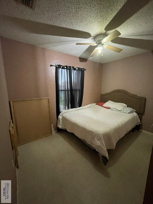 unfurnished bedroom featuring ceiling fan, a textured ceiling, and carpet