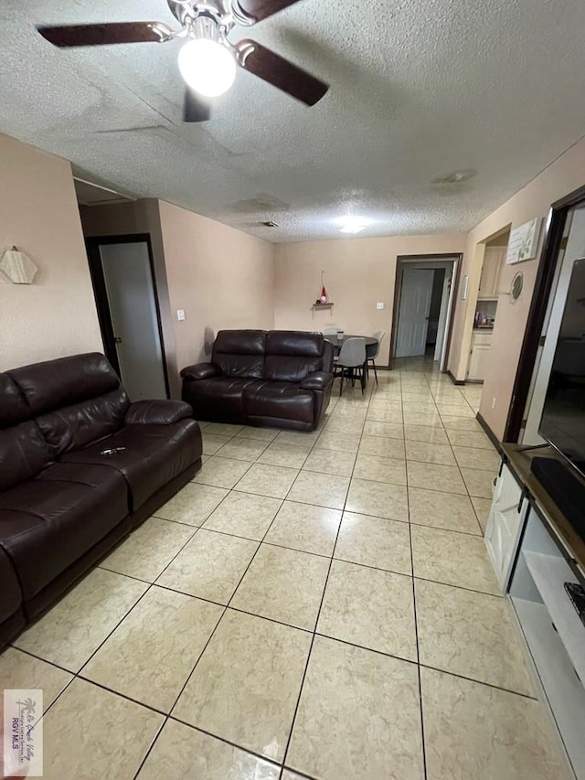 tiled living room featuring ceiling fan and a textured ceiling