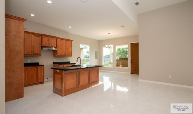 kitchen with a center island with sink, a chandelier, sink, and decorative light fixtures