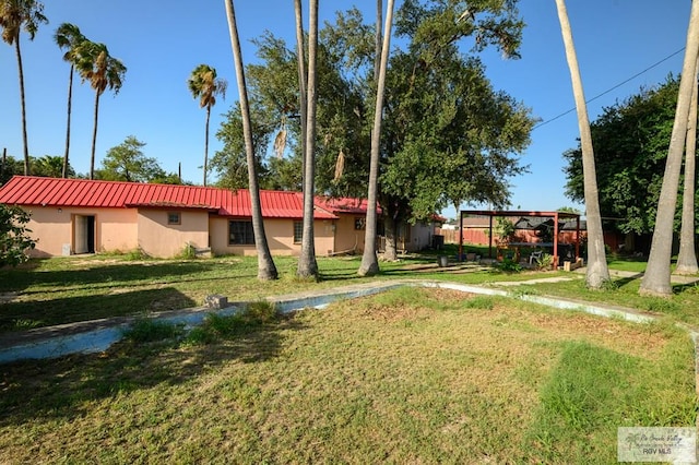 307 W Boone Ave, Pharr, TX 78577 - view of front of home with a metal roof, a front yard, and stucco siding