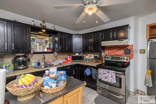 307 W Boone Ave, Pharr, TX 78577 - kitchen featuring stainless steel appliances, under cabinet range hood, light tile patterned flooring, backsplash, and dark cabinetry