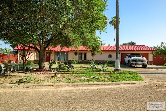 307 W Boone Ave, Pharr, TX 78577 - ranch-style home featuring an attached garage, a metal roof, driveway, and stucco siding