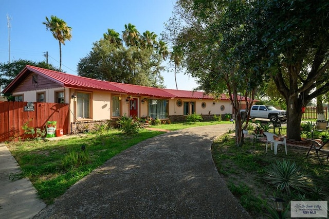 307 W Boone Ave, Pharr, TX 78577 - ranch-style house featuring stucco siding, curved driveway, and a metal roof
