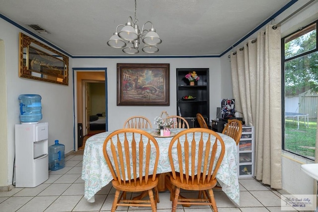 307 W Boone Ave, Pharr, TX 78577 - dining area with light tile patterned flooring, a chandelier, and crown molding