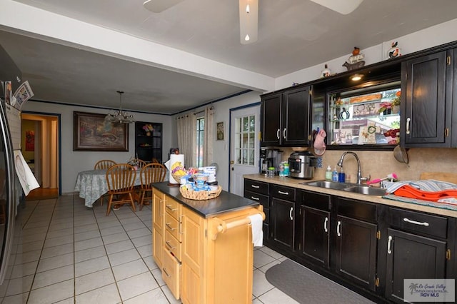 307 W Boone Ave, Pharr, TX 78577 - kitchen with light tile patterned flooring, dark cabinetry, and a kitchen island