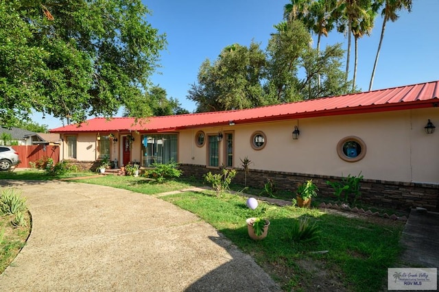 307 W Boone Ave, Pharr, TX 78577 - view of front of house featuring stucco siding and a metal roof