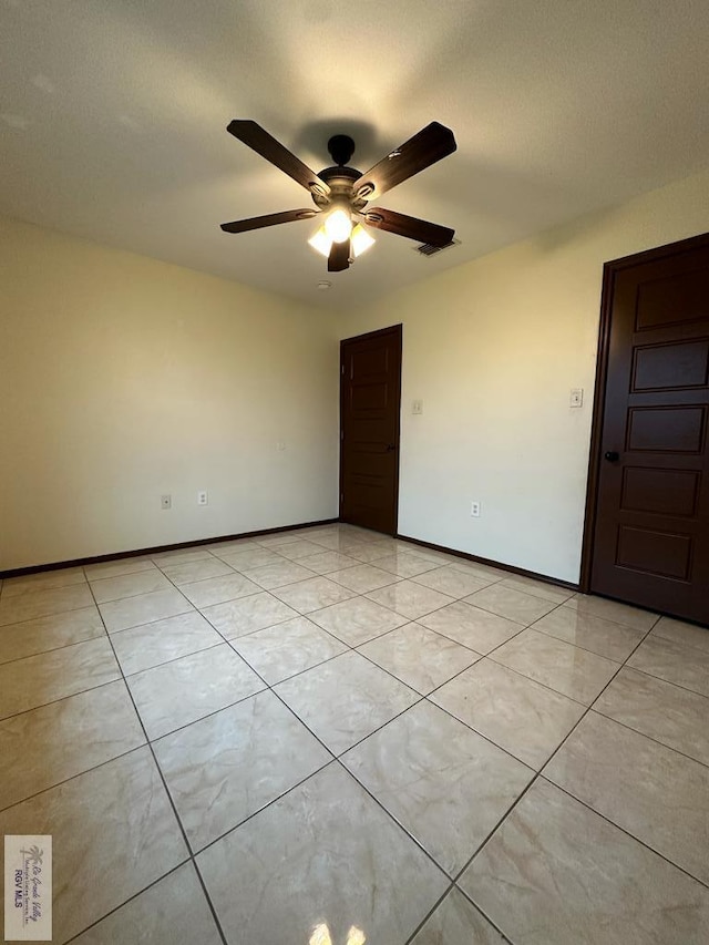 unfurnished room featuring ceiling fan and light tile patterned floors