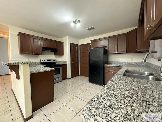 kitchen featuring sink, black fridge, a kitchen breakfast bar, kitchen peninsula, and electric stove