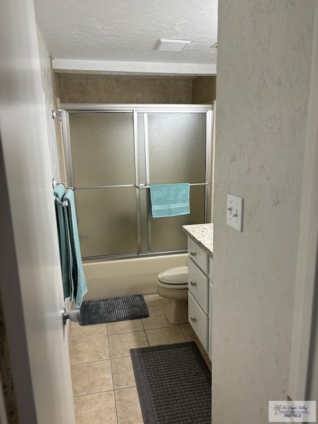 full bathroom with toilet, vanity, tile patterned floors, and shower / bath combination with glass door