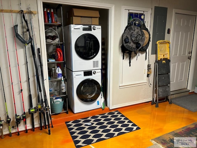 clothes washing area with electric panel and stacked washer and dryer