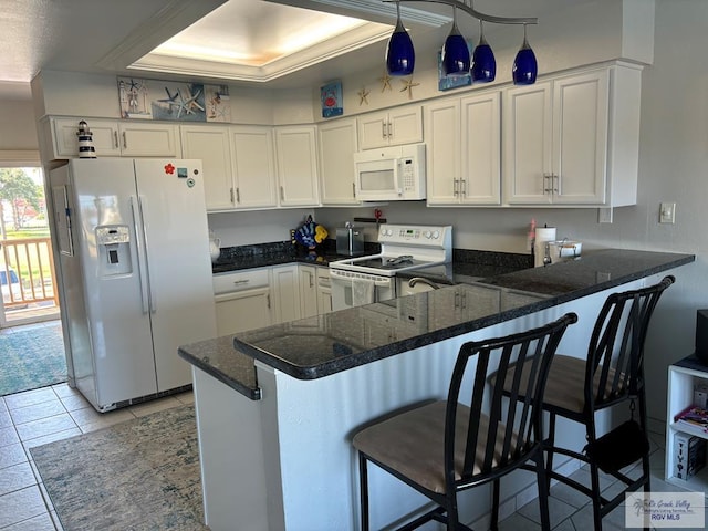 kitchen featuring kitchen peninsula, white appliances, white cabinets, and a breakfast bar area