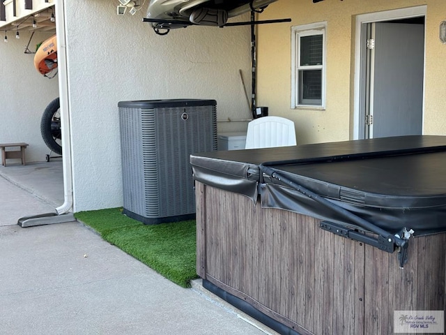 view of patio / terrace featuring a hot tub and cooling unit