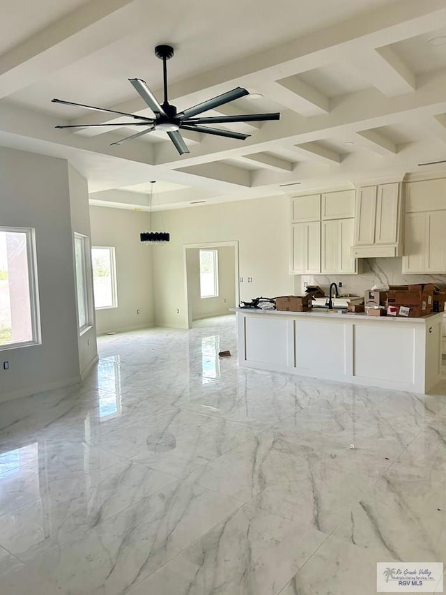 kitchen with coffered ceiling, ceiling fan, a healthy amount of sunlight, and white cabinetry