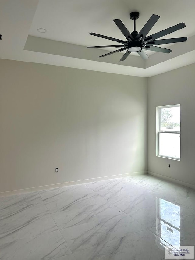 unfurnished room with a raised ceiling and ceiling fan