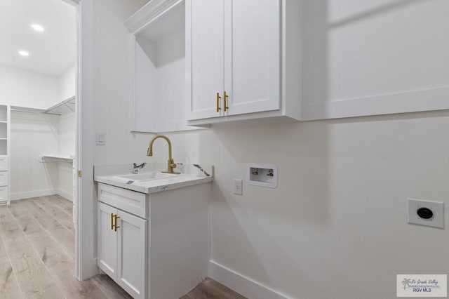 1305 Thacker Ln, Harlingen, TX 78552 - laundry area with electric dryer hookup, hookup for a washing machine, cabinet space, light wood-style floors, and recessed lighting