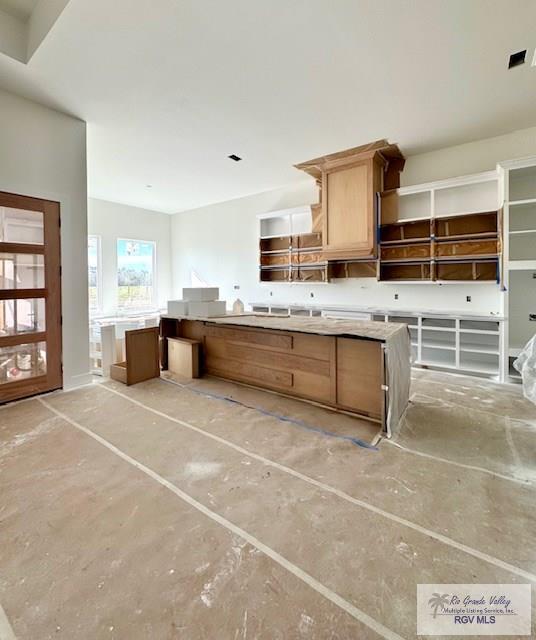 kitchen with open shelves, light countertops, visible vents, and unfinished concrete floors