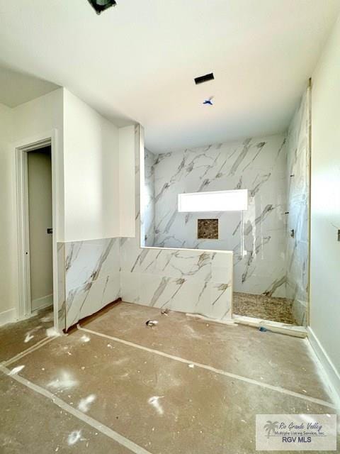 bathroom featuring a marble finish shower