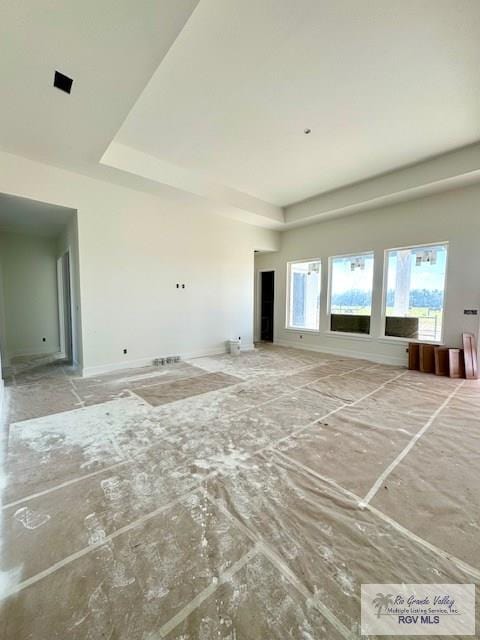 unfurnished living room featuring a tray ceiling