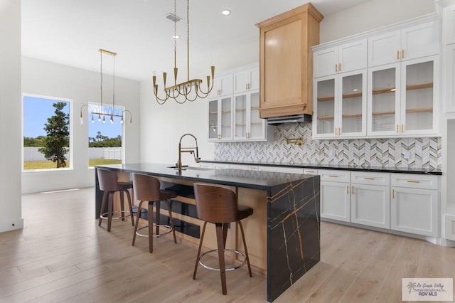 1305 Thacker Ln, Harlingen, TX 78552 - kitchen with dark countertops, decorative backsplash, a kitchen breakfast bar, a center island with sink, and recessed lighting