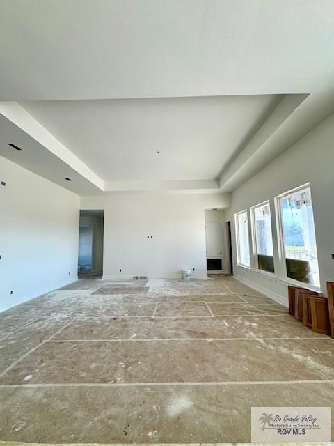 unfurnished living room featuring a raised ceiling