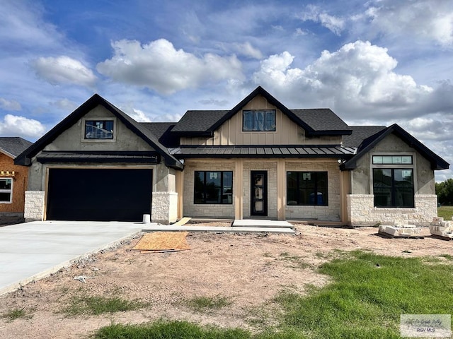 2625 Marky St, Harlingen, TX 78552 - view of front of house with stone siding, driveway, a standing seam roof, and roof with shingles