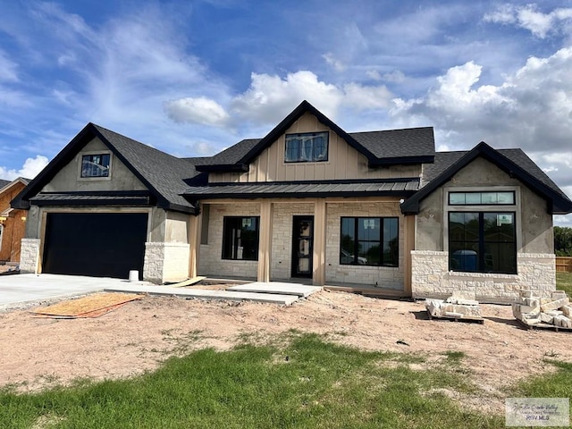 2625 Marky St, Harlingen, TX 78552 - view of front of house with stone siding, concrete driveway, a standing seam roof, board and batten siding, and roof with shingles