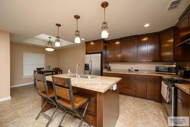 23314 Grapefruit Ave, Harlingen, TX 78552 - kitchen featuring stainless steel appliances, recessed lighting, light stone counters, a breakfast bar area, and a kitchen island with sink