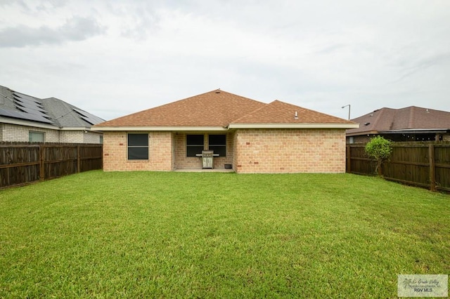 23314 Grapefruit Ave, Harlingen, TX 78552 - back of property featuring a fenced backyard, brick siding, and a shingled roof